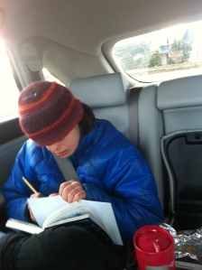 Kate writing a note in the back seat